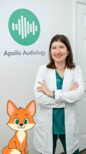 Dr. Davis in front of Apollo Audiology logo next to Fox mascot