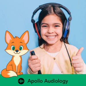 child with audiology headphones giving a thumbs up